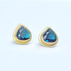 Heart-shaped blue-green tourmaline earrings with gold settings on a light gray background