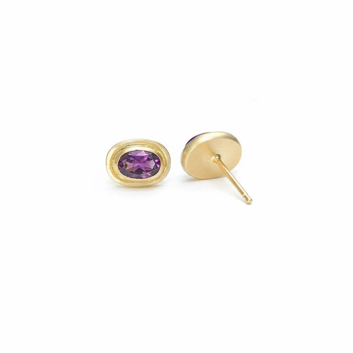Gold earrings with a purple sapphire showing back of earring

