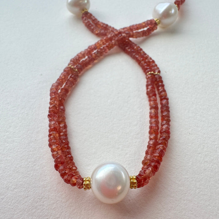 Necklace with orange sapphires and white pearls on a light background